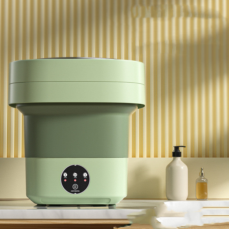 Mini Foldable Washing Machine in green color on a countertop with stylish background.