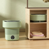 Mini Foldable Washing Machine displayed beside neatly folded clothes in a modern storage unit.